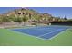 View of a community tennis court with mountain views, landscaping and seating at 7291 E Eagle Feather Rd, Scottsdale, AZ 85266