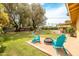 Inviting backyard featuring a fire pit, Adirondack chairs, a lush lawn, and mature trees at 7307 N 17Th Ave, Phoenix, AZ 85021