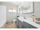 Well-lit bathroom featuring a large sink, white tiled walls, and a neutral-toned floor at 7307 N 17Th Ave, Phoenix, AZ 85021