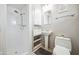 Bathroom with white tiled walls and shower area, stand-alone sink, and built-in shelving at 7307 N 17Th Ave, Phoenix, AZ 85021