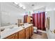 Bathroom featuring double sinks, a large mirror, and stylish decor with neutral color palette at 7342 E Norwood St, Mesa, AZ 85207