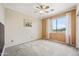 Bright bedroom with neutral tones, carpet flooring, ceiling fan, and large window at 7342 E Norwood St, Mesa, AZ 85207