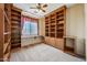 Bedroom featuring built-in bookshelves, a window with a slim desk, and neutral walls and carpeted floor at 7342 E Norwood St, Mesa, AZ 85207