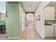 Hallway featuring tiled floors leading past a staircase, laundry room, and kitchen area at 7342 E Norwood St, Mesa, AZ 85207