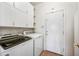 Laundry room features modern washer and dryer, upper cabinets, shelves, and tiled floors at 7342 E Norwood St, Mesa, AZ 85207