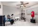 A spacious room with multiple exercise machines, a ceiling fan, and natural light from the window at 7460 E Kiowa Ave, Mesa, AZ 85209