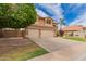 A tan house featuring a well-manicured lawn and three-car garage at 7460 E Kiowa Ave, Mesa, AZ 85209