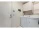 Functional laundry room with washer, dryer, and upper cabinets for storage and organization at 7460 E Kiowa Ave, Mesa, AZ 85209