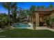 Lush backyard with a sparkling pool, mature palm trees, and a covered patio perfect for outdoor living at 7587 W Quail Ave, Glendale, AZ 85308