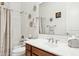 Full bathroom showcasing white fixtures, wood cabinetry, and decorative towel racks at 7587 W Quail Ave, Glendale, AZ 85308
