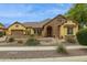 Beautiful exterior view showcasing desert landscaping, a stone accent wall, and tan stucco at 7587 W Quail Ave, Glendale, AZ 85308