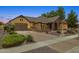 Charming single-story home featuring a stone facade, well-manicured landscaping, and a paver driveway at 7587 W Quail Ave, Glendale, AZ 85308