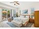 Bright main bedroom boasts outside access, sitting area, ceiling fan, and cozy coastal decor at 7587 W Quail Ave, Glendale, AZ 85308
