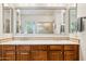 Double sink vanity featuring framed mirror and dark wood cabinetry for ample storage at 7587 W Quail Ave, Glendale, AZ 85308