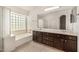 Bright bathroom features a double vanity and tub, offering comfort and convenience at 8214 S 48Th Dr, Laveen, AZ 85339