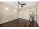 Spacious bedroom featuring dark wood floors, a ceiling fan, and plenty of natural light from two windows at 8214 S 48Th Dr, Laveen, AZ 85339