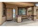 Covered front porch with a seating area and security door. The house number is visible above the door at 8214 S 48Th Dr, Laveen, AZ 85339