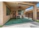 Covered patio has a ceiling fan, outdoor table, and artificial turf at 8214 S 48Th Dr, Laveen, AZ 85339