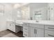 Bright bathroom featuring double vanities, a large mirror, and a walk-in shower at 9418 W Minnezona Ave, Phoenix, AZ 85037