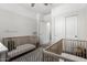 Bedroom with two cribs, neutral colors, and simple decor at 9418 W Minnezona Ave, Phoenix, AZ 85037