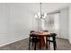 Dining room with a round table, four chairs, modern chandelier and wood-look flooring at 9418 W Minnezona Ave, Phoenix, AZ 85037