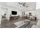 Open-concept living room and kitchen with modern furnishings and tile flooring at 9418 W Minnezona Ave, Phoenix, AZ 85037