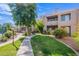 Beautifully landscaped exterior view of the apartment complex with lush green grass and mature trees at 11260 N 92Nd St # 2111, Scottsdale, AZ 85260
