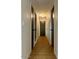 Hallway view featuring wood-look flooring, white walls, and multiple dark-colored doors at 1149 S 98Th St, Mesa, AZ 85208
