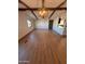 Open-concept living room with vaulted ceilings, wood-look flooring, and elegant lighting fixture at 1149 S 98Th St, Mesa, AZ 85208