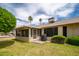 Inviting backyard with covered patio, well-maintained lawn, and lush landscaping at 13055 W Tangelo Dr, Sun City West, AZ 85375