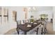 Elegant dining room with a stylish chandelier, large windows, and a view of the living area at 13055 W Tangelo Dr, Sun City West, AZ 85375