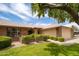 Charming single-story brick home featuring a well-manicured lawn, mature trees, and an attached two-car garage at 13055 W Tangelo Dr, Sun City West, AZ 85375