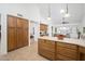 Spacious kitchen featuring wood cabinetry, an island with countertop seating, and a view of the adjacent living space at 13055 W Tangelo Dr, Sun City West, AZ 85375