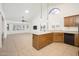 Open concept kitchen with tile flooring, island, natural light, and open to a living area at 13055 W Tangelo Dr, Sun City West, AZ 85375