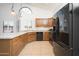 Modern kitchen featuring wooden cabinetry, tile flooring, and sleek black appliances at 13055 W Tangelo Dr, Sun City West, AZ 85375