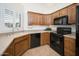 Well-equipped kitchen with wood cabinets, countertops, modern appliances, and tile backsplash at 13055 W Tangelo Dr, Sun City West, AZ 85375