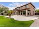 Backyard showcasing manicured turf, a stone patio, and the home's exterior at 13367 W Jesse Red Dr, Peoria, AZ 85383