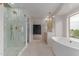 Bright bathroom featuring a soaking tub and glass shower at 13367 W Jesse Red Dr, Peoria, AZ 85383