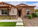 Inviting entryway of home with stone accents, manicured landscaping, and artificial turf at 13367 W Jesse Red Dr, Peoria, AZ 85383