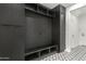 Stylish mudroom with dark cabinets, open shelving, bench, and a patterned tile floor at 13367 W Jesse Red Dr, Peoria, AZ 85383