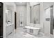 A luxurious bathroom features a freestanding tub, a decorative chandelier, and neutral-tone tile at 13750 E Yucca St, Scottsdale, AZ 85259