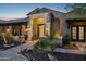 Inviting front entrance with manicured landscaping, a tiled walkway, and stone accents at dusk at 13750 E Yucca St, Scottsdale, AZ 85259
