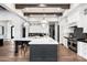 Spacious kitchen featuring a large island, wooden beams, stainless steel appliances, and white cabinetry at 13750 E Yucca St, Scottsdale, AZ 85259