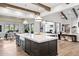 An open-concept kitchen features a large island with a sink and dining area, plus hardwood floors and exposed beams at 13750 E Yucca St, Scottsdale, AZ 85259