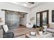 Cozy living room with a sliding barn door, fireplace, and a large window overlooking the backyard at 13750 E Yucca St, Scottsdale, AZ 85259