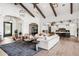Open-concept living room with high ceilings, wood beams, and stylish furnishings, open to the kitchen at 13750 E Yucca St, Scottsdale, AZ 85259