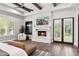Cozy main bedroom with a fireplace, ceiling fan, and hardwood floors at 13750 E Yucca St, Scottsdale, AZ 85259
