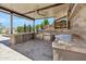 An outdoor kitchen includes stainless steel appliances, a ceiling fan, and a built-in television at 13750 E Yucca St, Scottsdale, AZ 85259