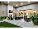 An outdoor patio includes a fireplace, television, ceiling fan, lounge chairs, and dining table and seating at 13750 E Yucca St, Scottsdale, AZ 85259