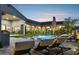 Lounge by the pool surrounded by lush landscaping, complete with outdoor kitchen, a grill, and water features at 13750 E Yucca St, Scottsdale, AZ 85259